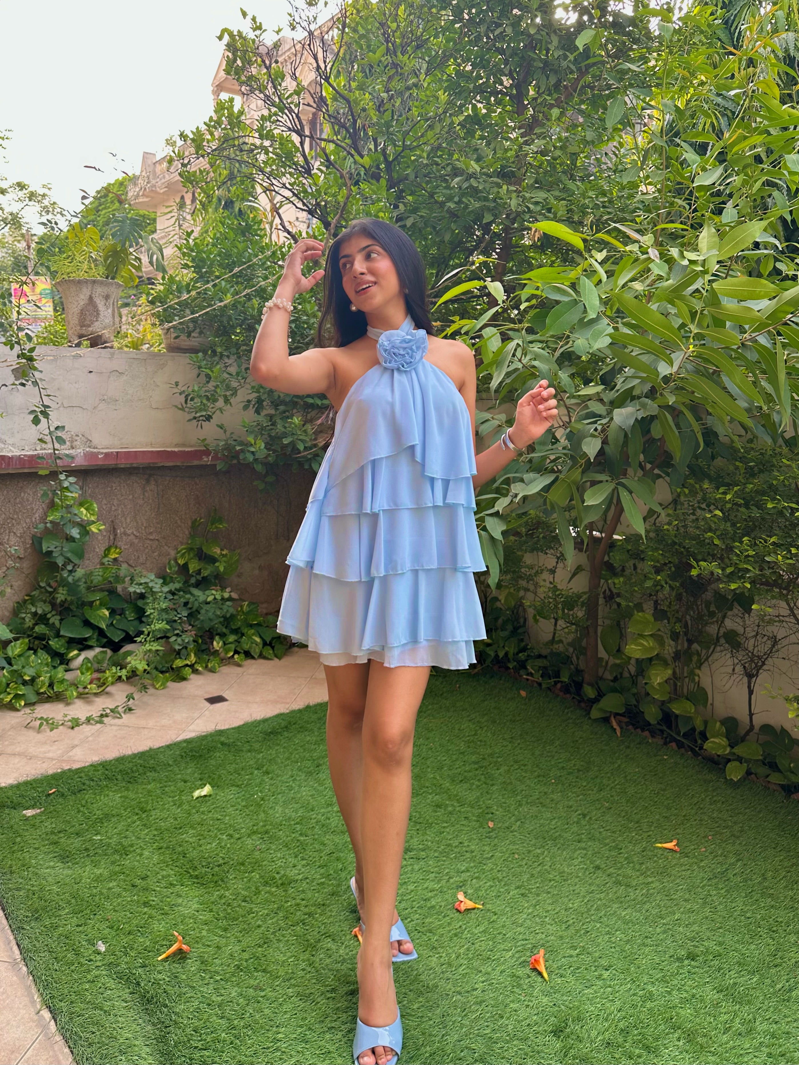 Light blue tiered ruffle mini dress with floral halter neckline, flowy chiffon layers, and feminine silhouette. Perfect for vacations, brunch dates, birthdays, summer parties, and Pinterest-inspired fashion. Trendy pastel blue dress for women with elegant and romantic styling.