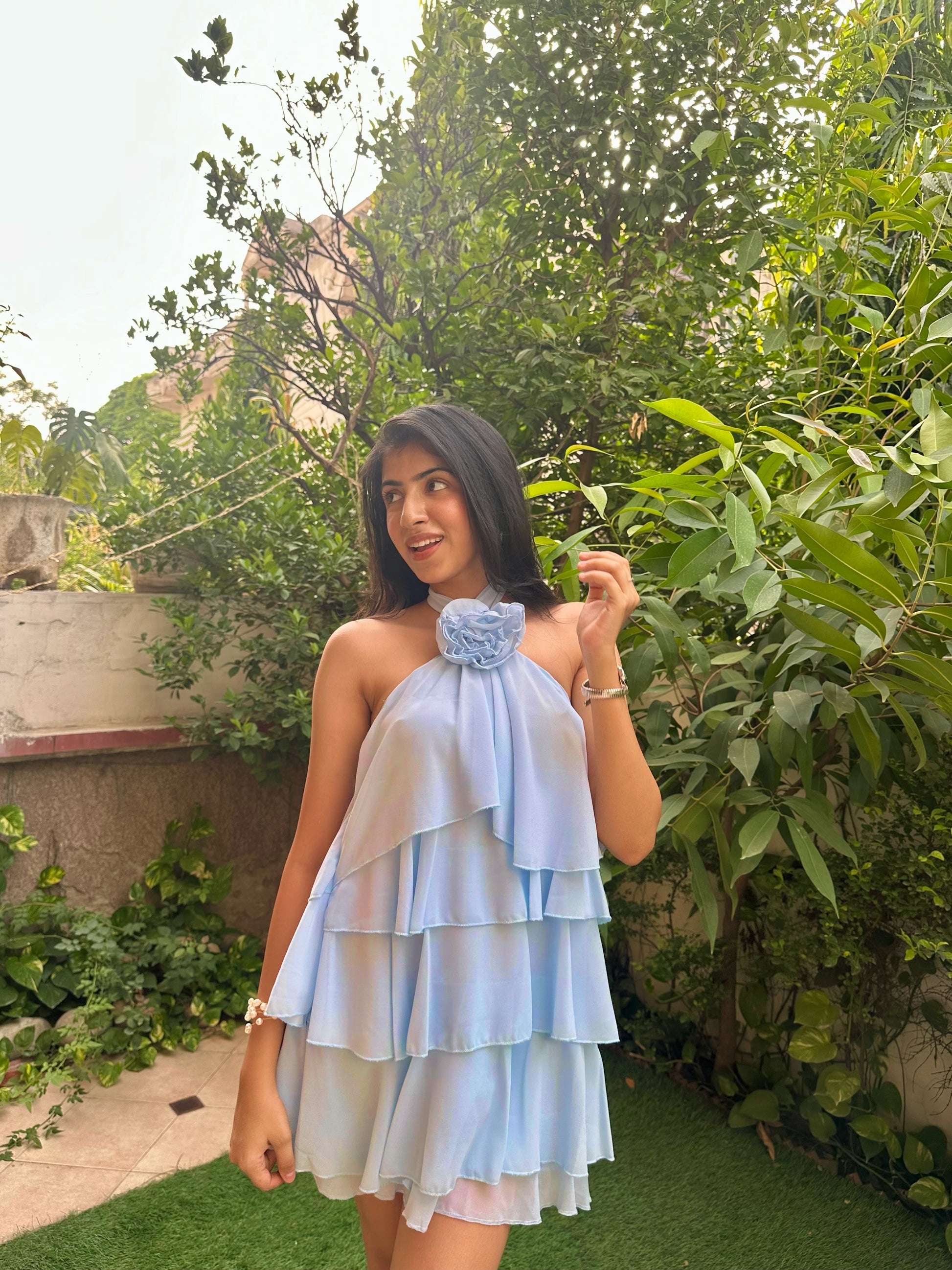 Light blue tiered ruffle mini dress with floral halter neckline, flowy chiffon layers, and feminine silhouette. Perfect for vacations, brunch dates, birthdays, summer parties, and Pinterest-inspired fashion. Trendy pastel blue dress for women with elegant and romantic styling.